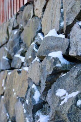 Close-up of a stone wall dusted with snow in Stockholm, Sweden.